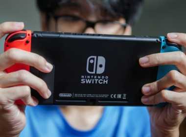 Tânăr care se joacă pe consola Nintendo Switch