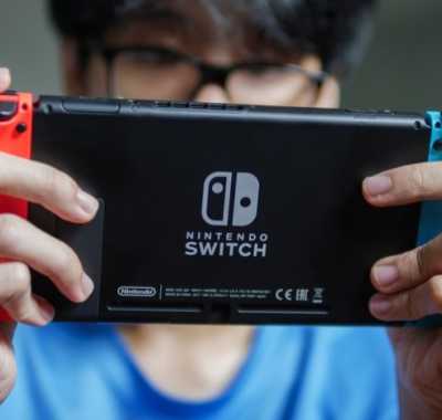 Tânăr care se joacă pe consola Nintendo Switch