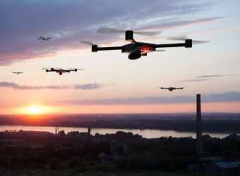 drone care zboară deasupra unui oraș la apus