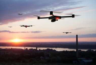 drone care zboară deasupra unui oraș la apus