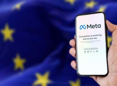 Telefon cu logoul Meta în fața unui steag al Uniunii Europene
