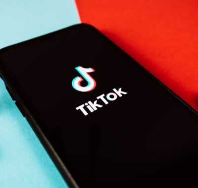 Telefon cu aplicația TikTok și căști wireless