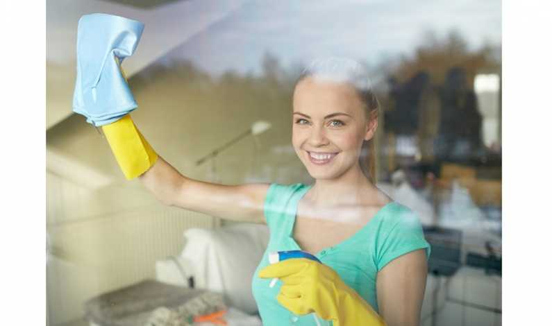 Femeie care zambeste in timp ce face curatenie