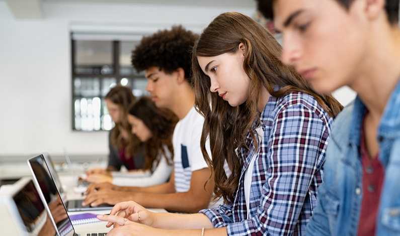Studenți cu laptop-uri în clasă